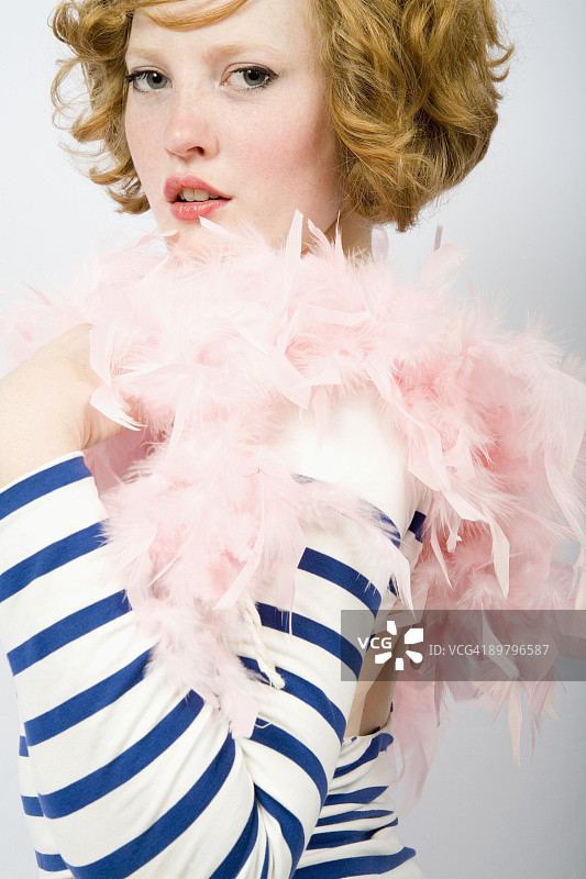 身穿条纹毛衣和羽毛围巾的年轻女子图片素材