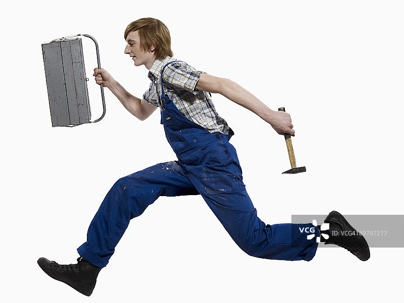 拿着工具箱和锤子奔跑的年轻人图片素材