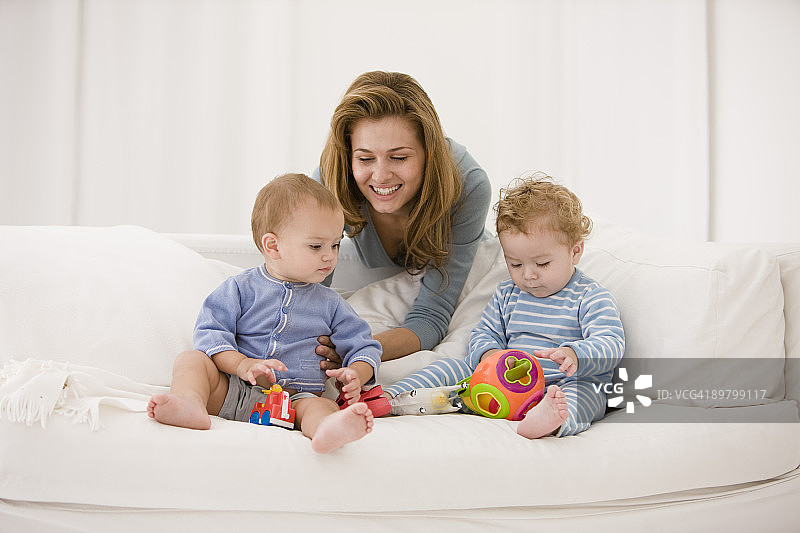 女人在沙发上和儿子女儿玩耍图片素材