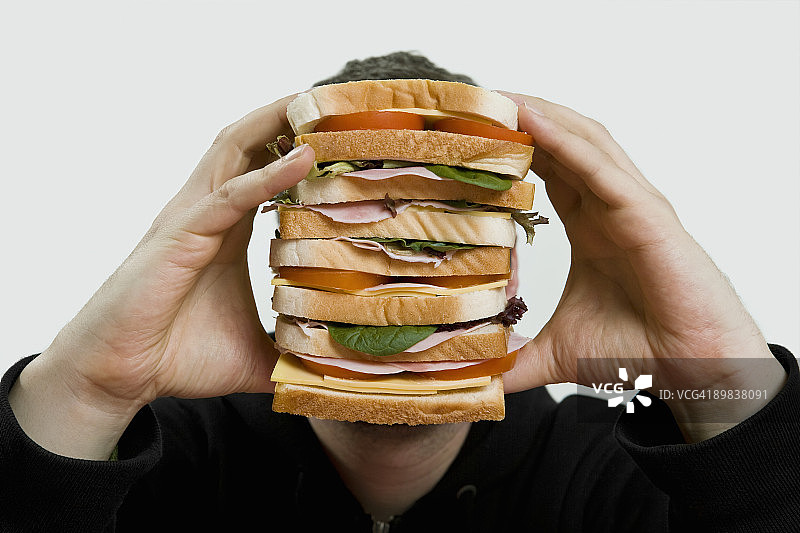男人拿着一个大三明治图片素材