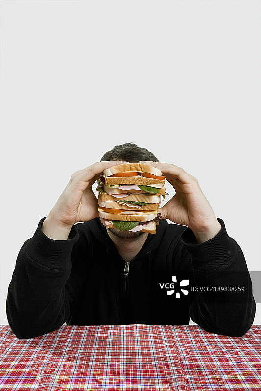 男人拿着一个大三明治图片素材