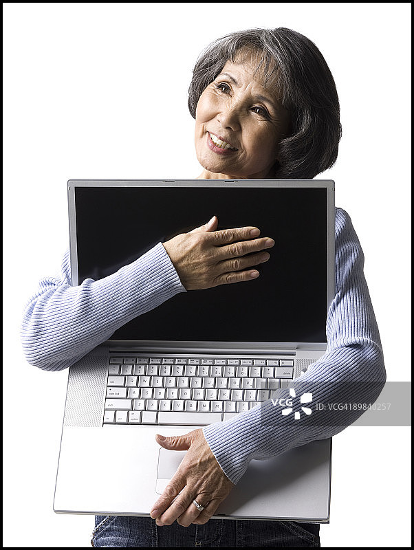 年长的女人拿着笔记本电脑图片素材