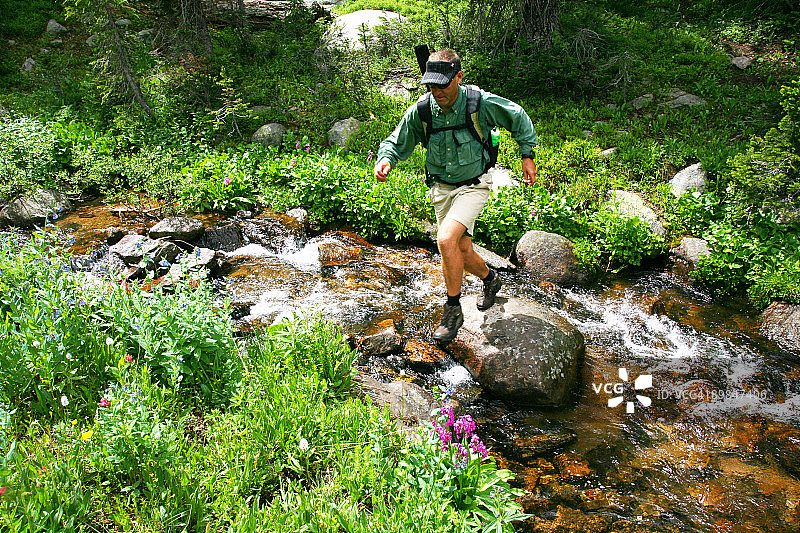 男子跳跃山涧图片素材