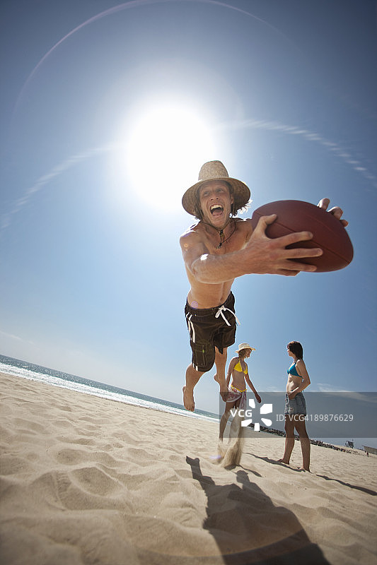 在海滩上空接足球的男人图片素材