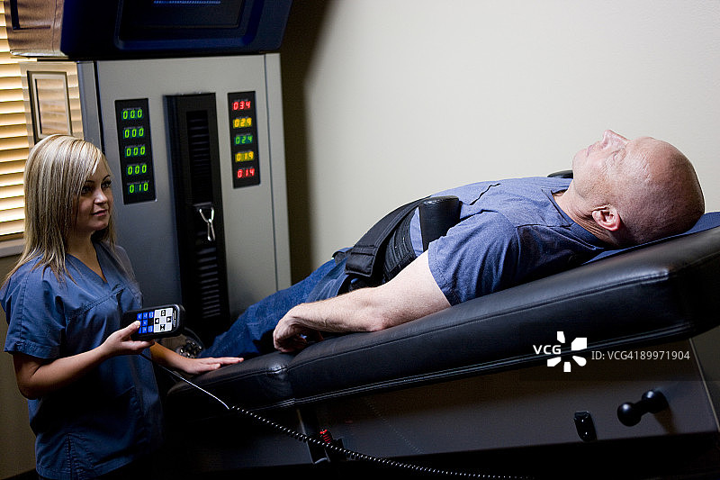 男子在脊椎按摩机上接受治疗图片素材