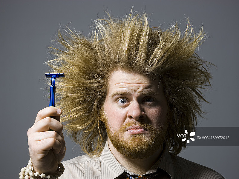 留着蓬乱头发的男人拿着剃须刀图片素材