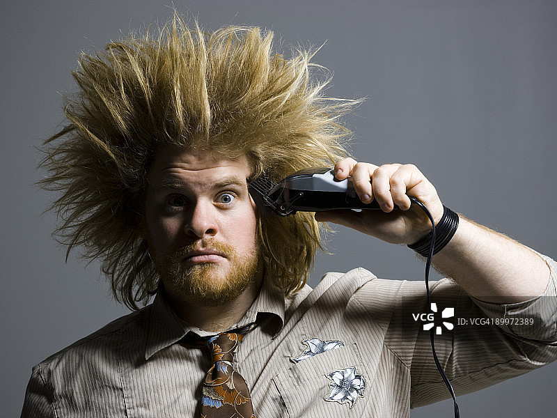 蓬乱头发的男人手持理发剪图片素材