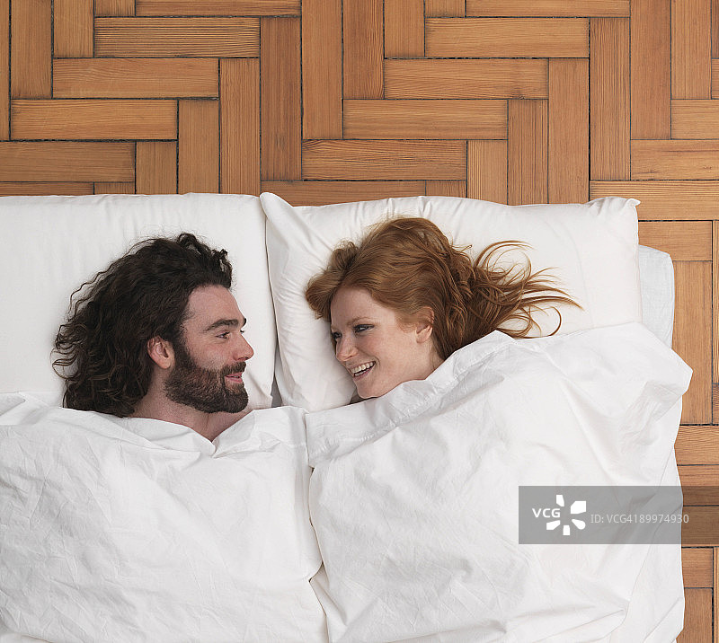 情侣躺在床上，微笑图片素材