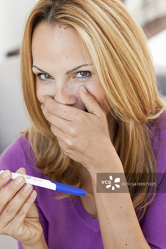 年轻女人手持验孕棒图片素材