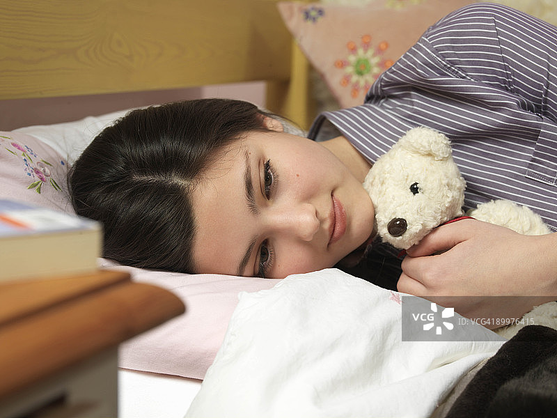 抱着泰迪熊的14岁女孩图片素材