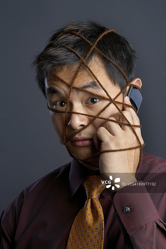 男人一边打电话一边系领带图片素材