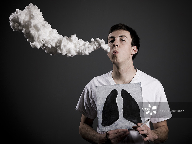 吸烟并展示黑色肺部图画的男人图片素材