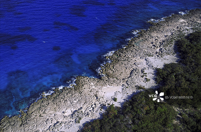 空中俯瞰珊瑚海岸线，展现红树林、珊瑚礁石和海水图片素材