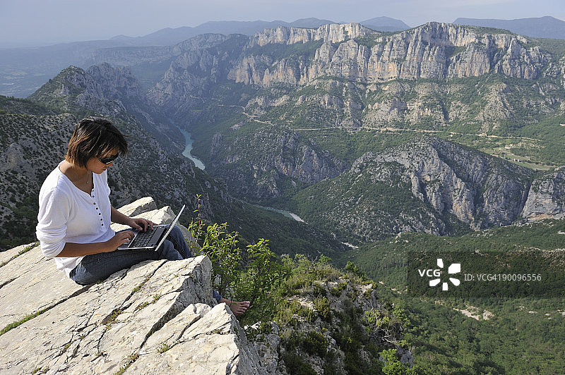女人在法国韦尔东峡谷使用笔记本电脑图片素材