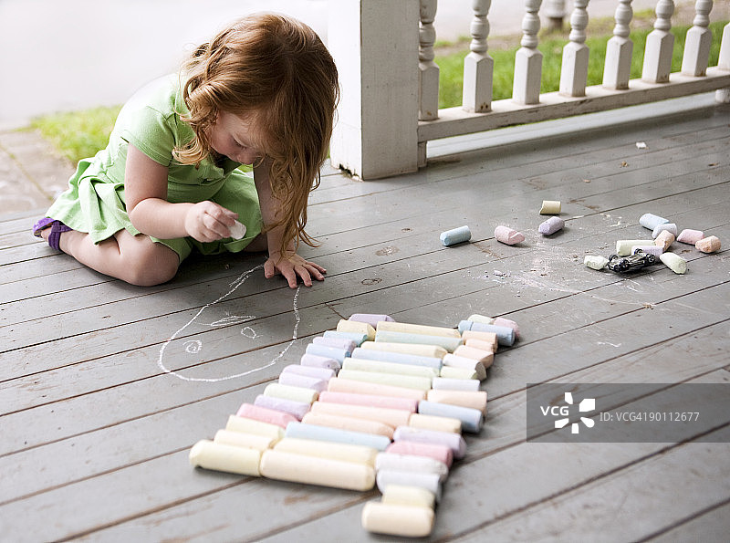 在门廊上用粉笔画画的女孩图片素材