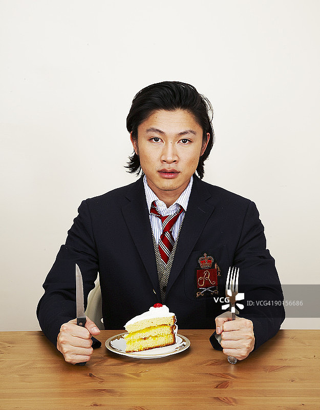 穿正装吃蛋糕的男人肖像图片素材