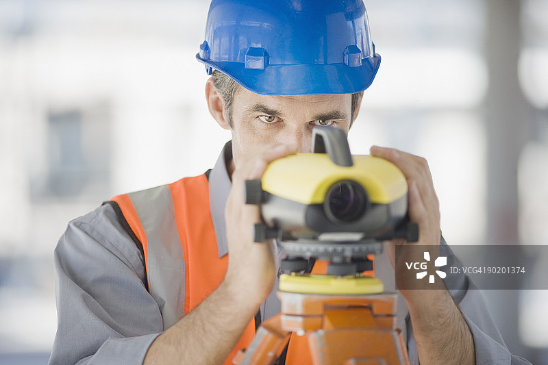 戴安全帽使用测量设备的测量员图片素材