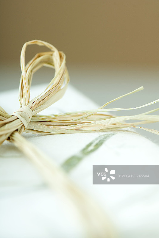 带有拉菲草蝴蝶结的包装礼物，特写镜头图片素材