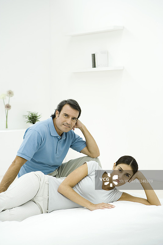 情侣在床上放松，对着镜头微笑图片素材