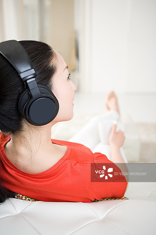 在沙发上听音乐的女人图片素材