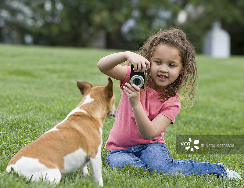 混血女孩给小狗拍照图片素材