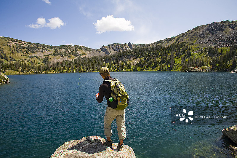 男人在高山湖泊飞蝇钓鱼图片素材