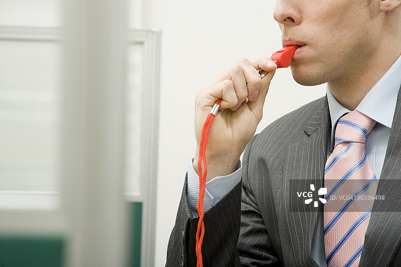 在办公室吹红色哨子的男人图片素材