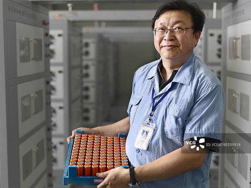 男子抱着一整箱电池图片素材