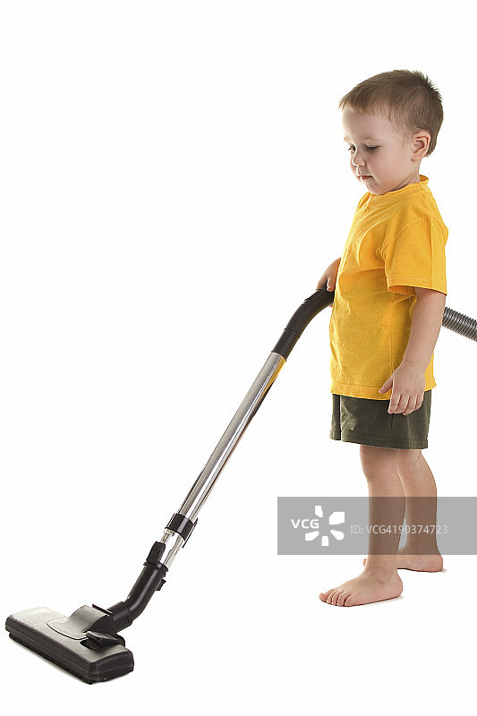 拿着真空吸尘器的小男孩图片素材