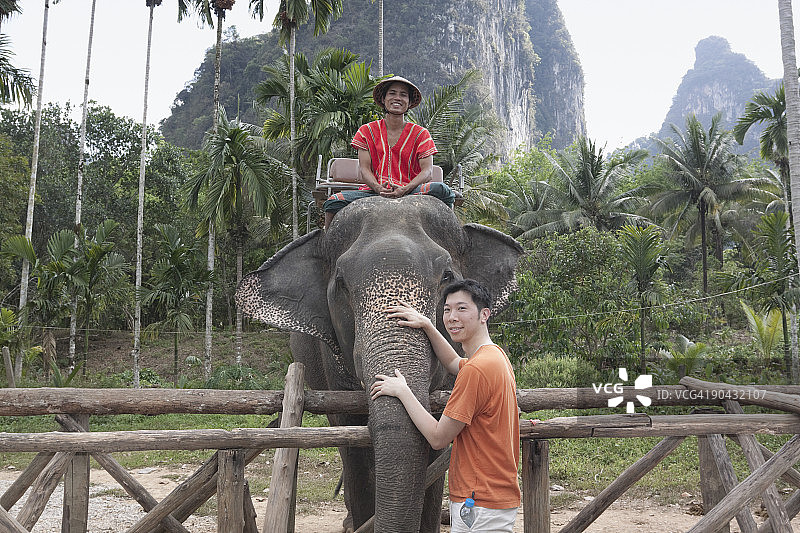 中国男人在泰国抚摸有骑手的象图片素材
