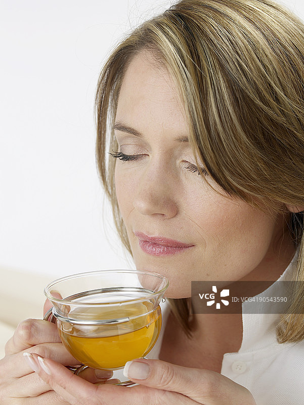 闭眼品茗的女人，特写镜头图片素材