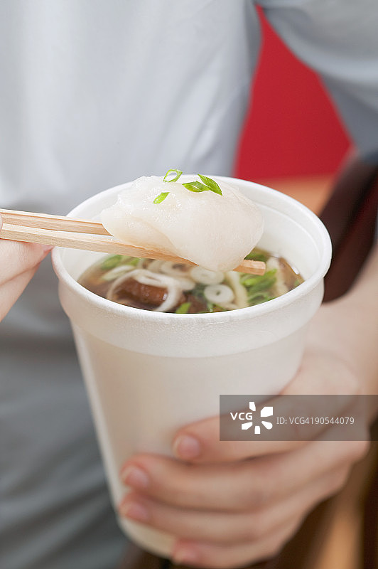 女人拿着一杯亚洲面条汤图片素材