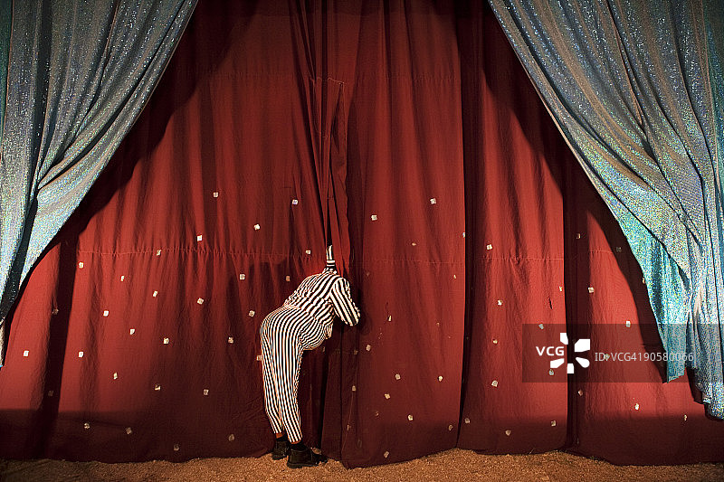 穿着戏服的男子从舞台帷幕后偷看图片素材