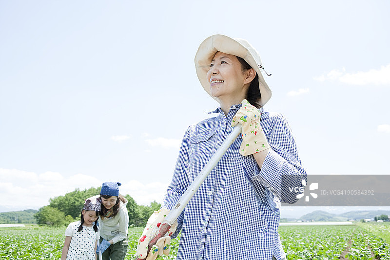 中年妇女在菜地里微笑图片素材