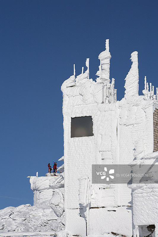 两人站在华盛顿山顶的积雪建筑甲板上图片素材