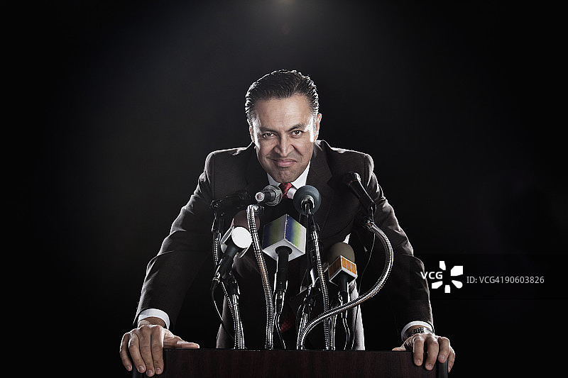 站在麦克风讲台上的西班牙裔男人图片素材