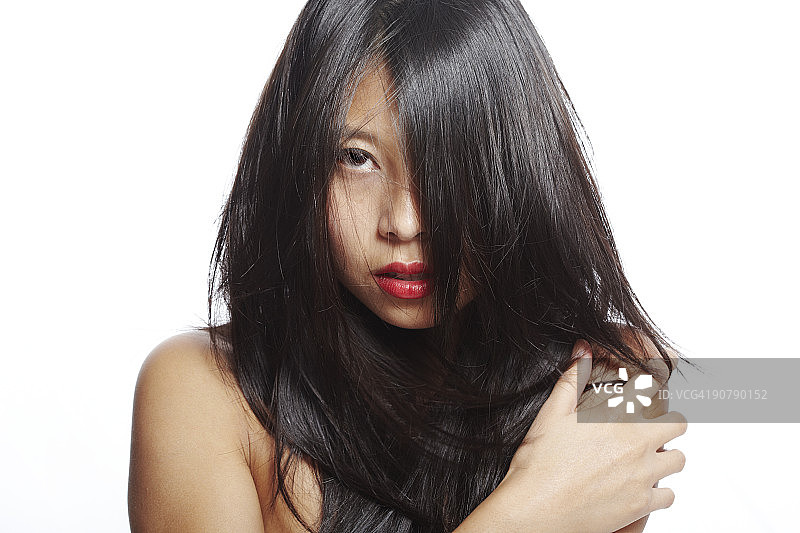 年轻漂亮的亚洲女性，头发遮面。图片素材
