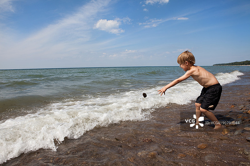 男孩向伊利湖扔石头图片素材