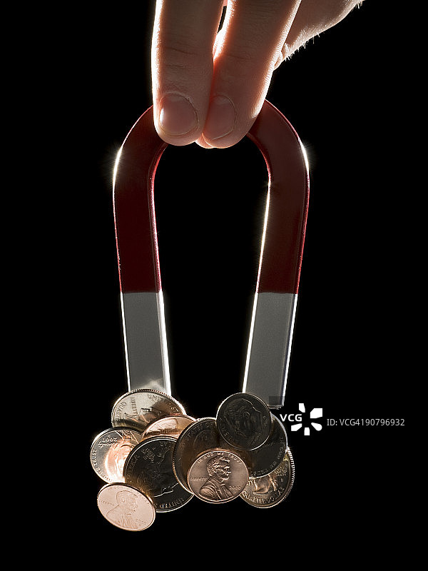 手持磁铁吸附硬币图片素材