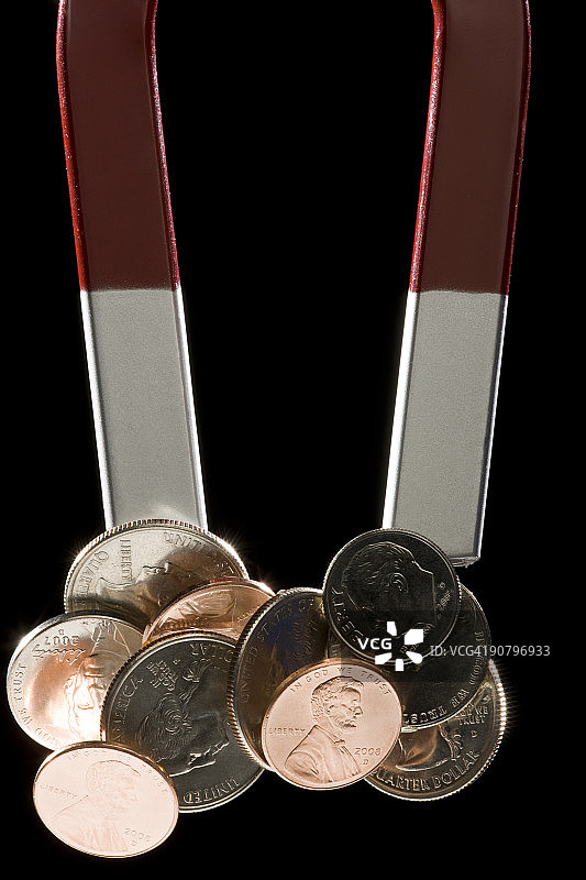 吸附着一堆硬币的磁铁图片素材