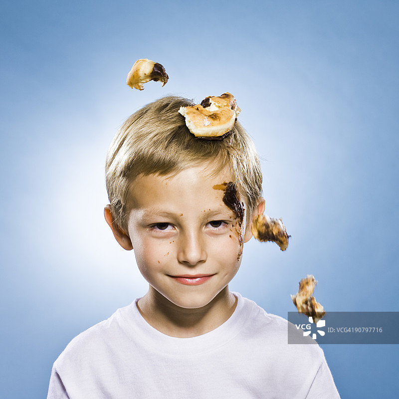 巧克力甜甜圈掉在男孩头上图片素材