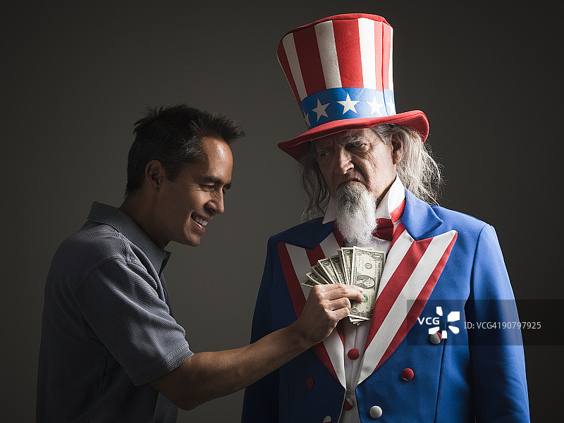 男人从山姆大叔外套中取钱图片素材