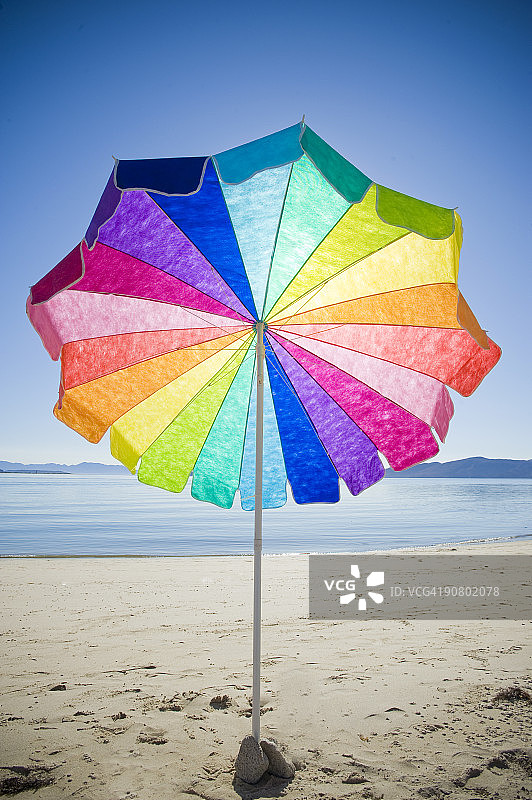 彩色雨伞，阳光明媚的空旷海滩图片素材