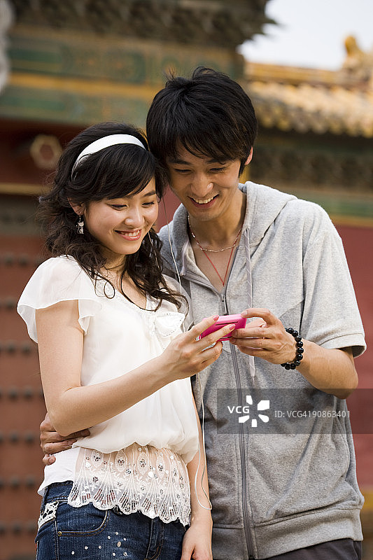 在户外微笑的年轻夫妇与mp3播放器图片素材
