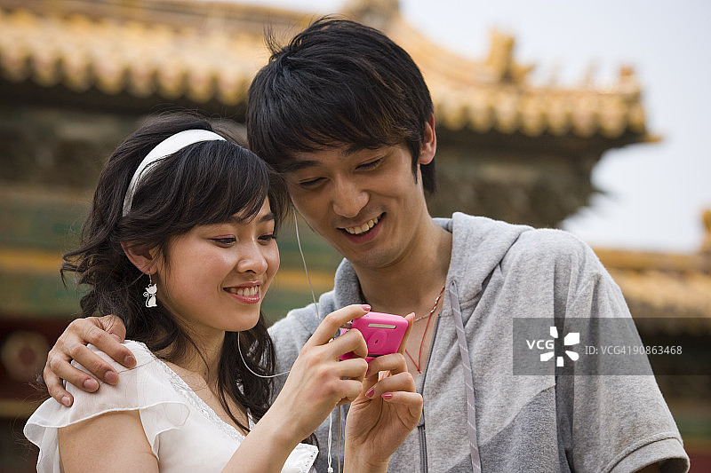 在户外微笑的年轻夫妇与mp3播放器图片素材