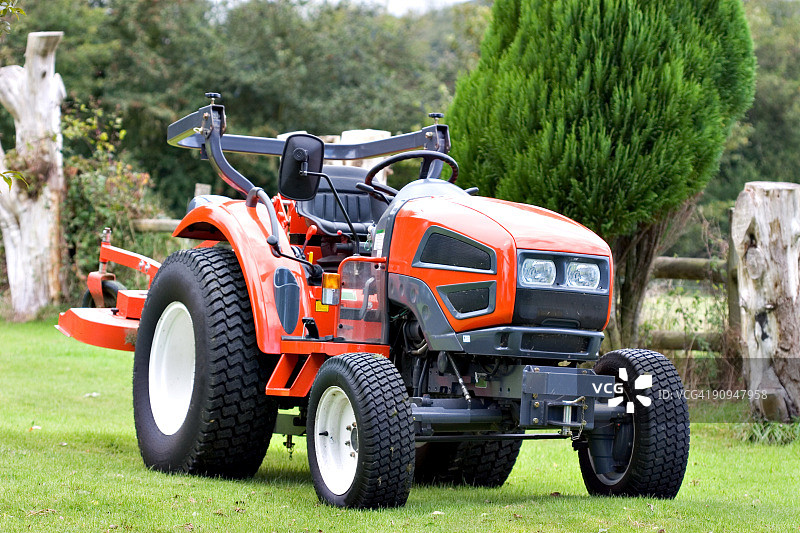 绿色草地上的鲜红色拖拉机图片素材