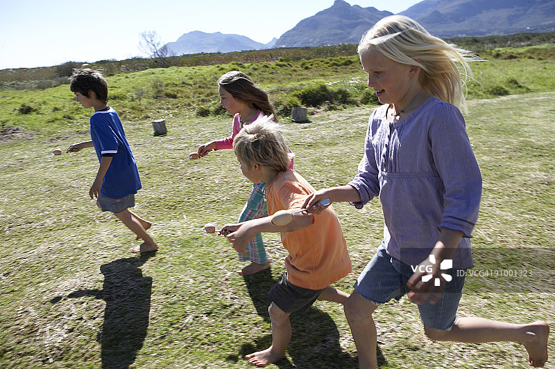 孩子们参加鸡蛋和勺子赛跑图片素材
