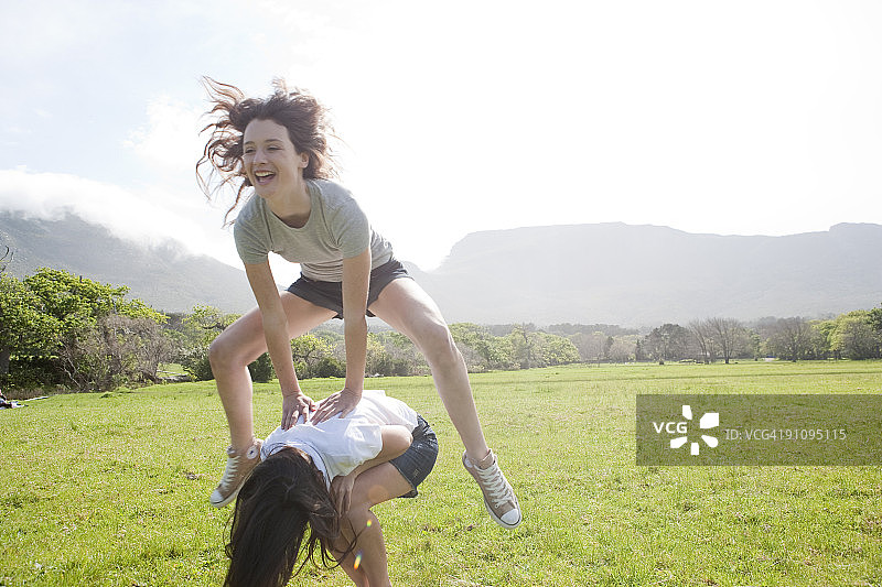 两位女士在田野里玩跳山羊图片素材