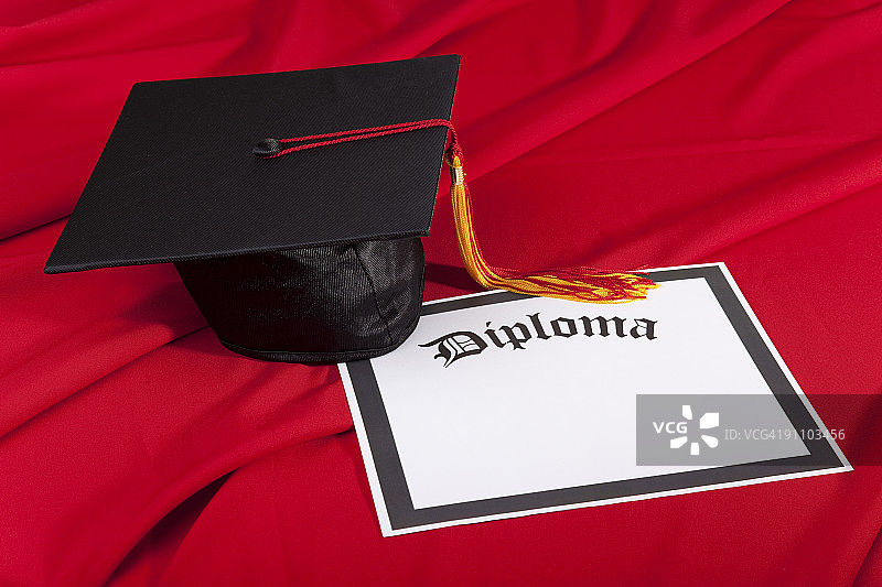 毕业帽和文凭红色背景图片素材