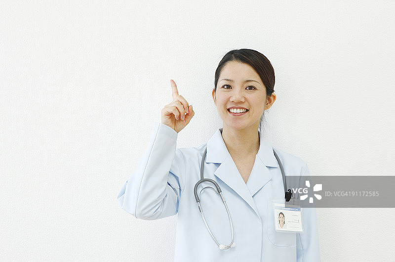 女医生举起食指，微笑着图片素材